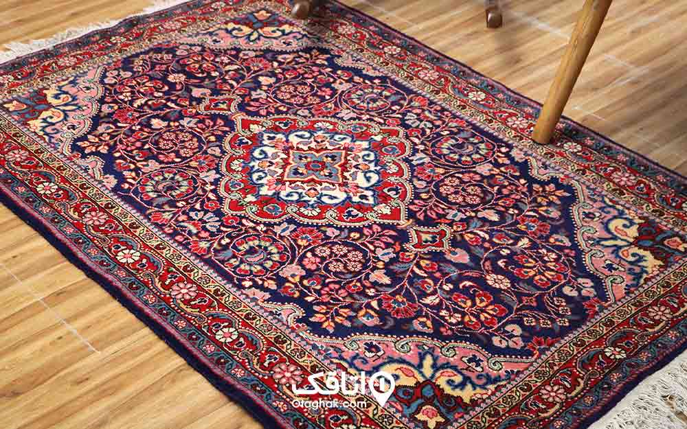 یک تخته فرش ایرانی که روی زمین پهن شده