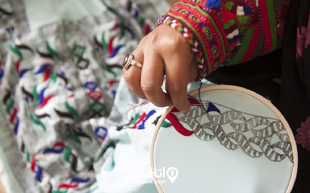 دستان خانمی در حال دوختن طرحی با هنر گلدوزی