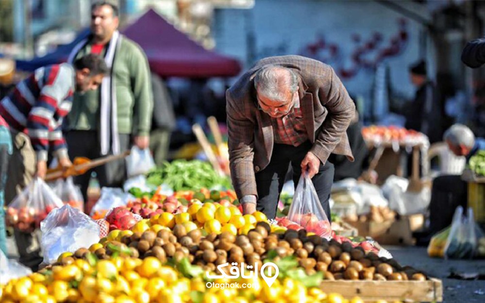 مردی در حال ریختن میوه در کیسه در یک بازار روز بزرگ 