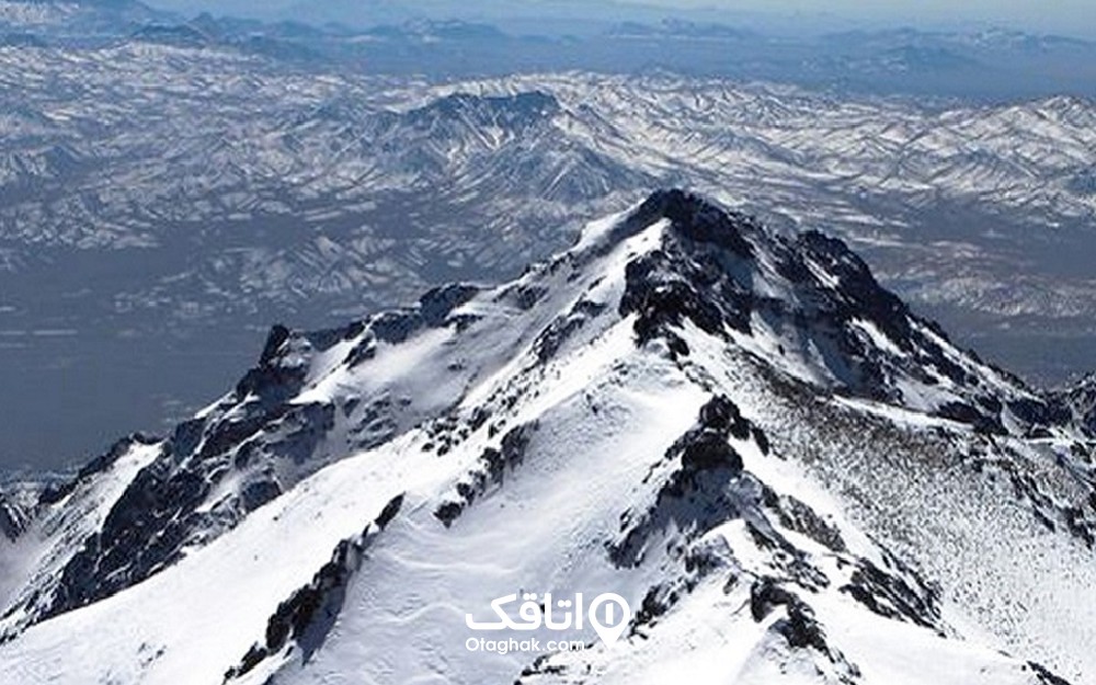 قله کوهی پوشیده شده از برف در یک منطقه کوهستانی