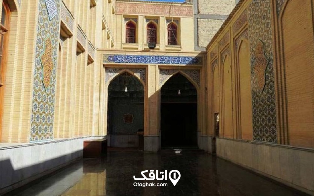 مسجدی با دیوار های اجری و در میان آن ها کاشی کاری های آبی رنگ