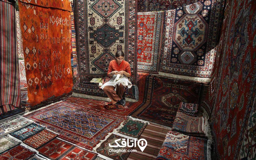 نمایی از یک دختر فرشباف در محاصره فرش‌های ارمنی
